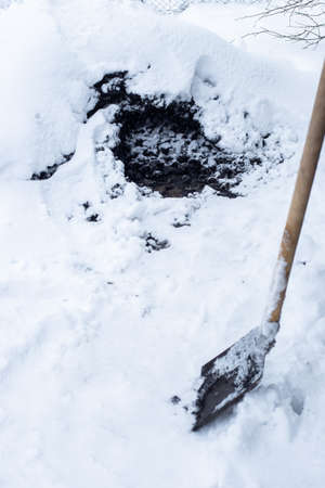 Black coal covered with snow and a shovel. Heating of a residential building in the countryside.の写真素材
