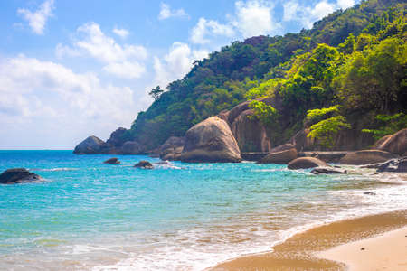 Seascape. Rocky seashore with tropical forest on the mountain. Beach holidays in Thailand.