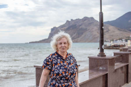 Portrait of an elderly gray-haired woman on the embankment of the sea. Recreation and pastime in retirement.の写真素材