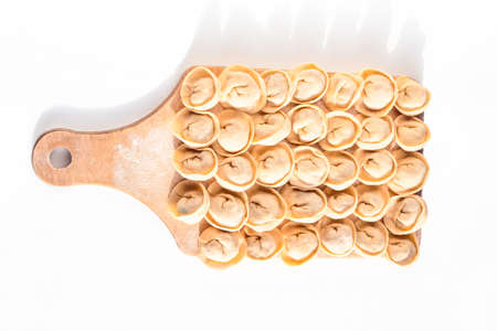 Raw Russian dumplings on a cutting board, on a white background. Cooking a traditional dish.の写真素材