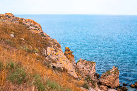 sea mountain landscape. Blue sea and rocks with dry grass. Travel and tourism.の写真素材