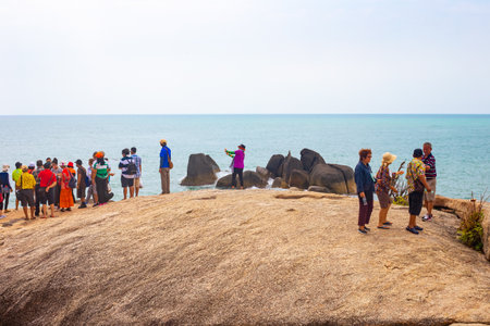 A group of Asian tourists sightseeing and taking pictures on the seashore on Koh Samui, Thailand - 05.03.2022のeditorial素材