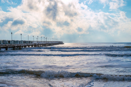 Long pier in the blue sea with wave and sky with clouds.の写真素材