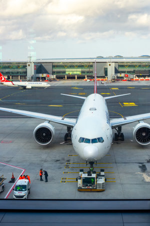 A large aircraft of a Turkish airline in the passenger boarding area, view from the airport building. Turkey, Istanbul-24.03.2022のeditorial素材
