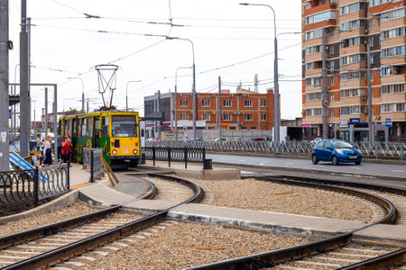 Yellow streetcar stopped at the station to drop off passengers. Public urban transport Krasnodar,...