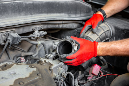 The car mechanic disconnected the air pipe from the car engine. car repairs.の写真素材