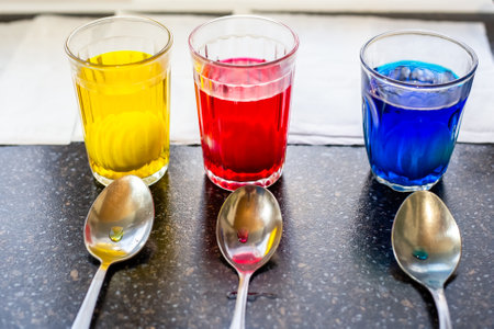 glasses with multi-colored paints in which eggs are painted for the feast of holy easter.の写真素材