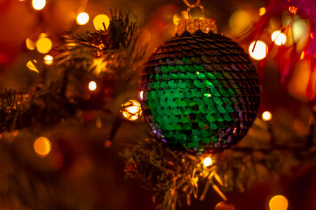 Christmas ball on a Christmas tree with blurred bokeh from the lights. Celebrating the New Year and Christmas.の写真素材