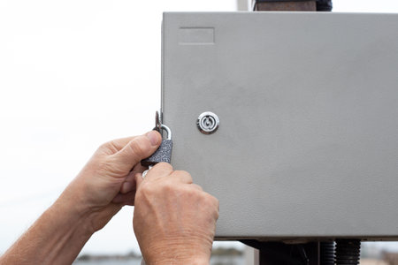 An electrician locks an electrical panel with automatic switches. Supplying electricity to the...