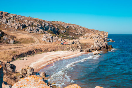 Seascape. Rocky sea coast with a small wave on a sunny summer day. General beaches of the Azov Sea.