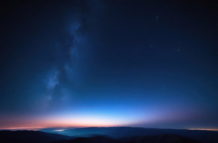 Dark blue starry sky with light from the sun on the horizon. Night landscape.の素材