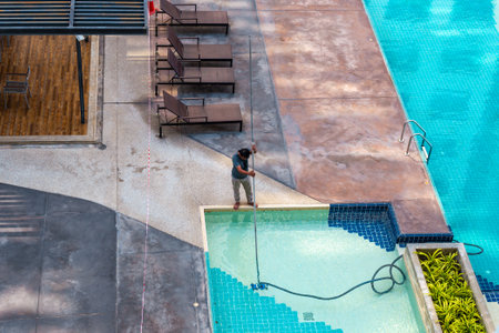 Worker cleaning a pool, view from above. Pool maintenance and care.の写真素材