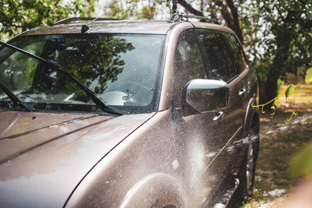 Washing your SUV car with a hose at home in your backyard.の写真素材