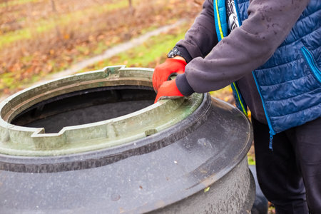 Plastic casing of the borehole walls. A worker installs a borehole for a pumping station in a garden.の写真素材