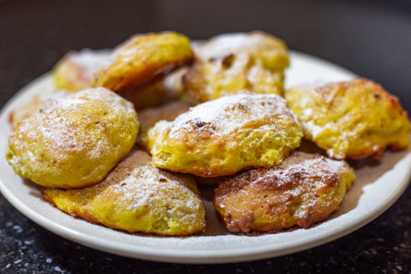 Bright orange pumpkin cookies baked in the oven, sprinkled with powdered sugar, on a white plate.の写真素材