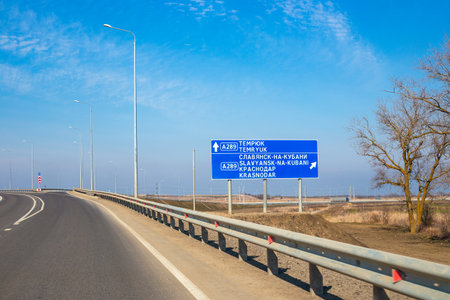 a sign indicating the direction of travel on a road on a spring day.の写真素材