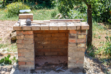 Front view of a brick barbecue structure in a garden nearing completion.の写真素材