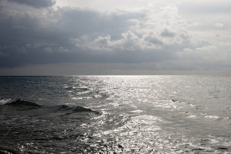 A calm seascape, on the horizon the ocean meets the cloudy sky, evoking a sense of the power of nature.の写真素材