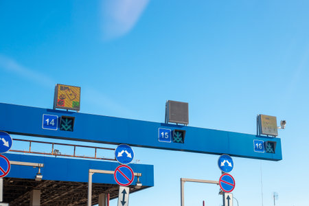 Toll roads. Close-up of a toll plaza structure with signs and directional arrows.の写真素材