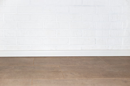 An interior with a white brick wall and beige tiled floor.