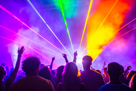 A crowd of people in a concert atmosphere with bright stage laser lighting. Entertainment and celebrations.の素材
