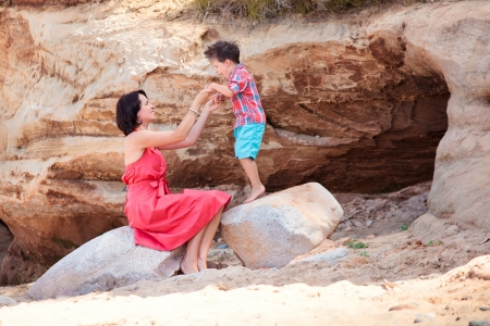 Young loving mother and her little son playing on the beach near the Red Cliffs, Latviaの写真素材