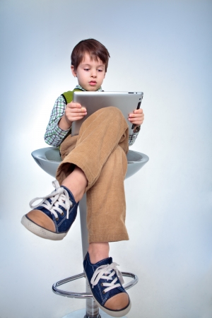 Child with a tablet pc  Boy playing on tablet isolated on white backgroundの写真素材