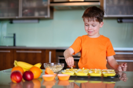 Cute little boy helping with baking cookies in the kitchenの写真素材