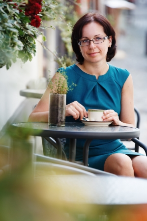 Elegant woman in a coffee break in a beautiful summer dayの写真素材