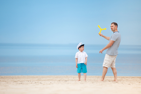 Father and son playing together on the beach  on tropical beach vacationの写真素材