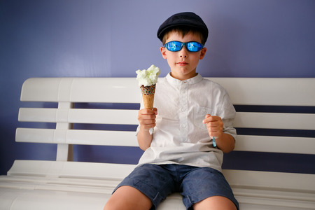Cute little boy eating ice cream at indoor cafe