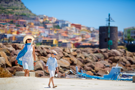 Mother and her little son walking outdoors in town Castelsardo, Sardinia, Italyの写真素材