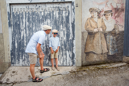 Happy father and son walking outdoors in village ORGOSOLO, ITALY. Murals wall paintings about political and historical facts in Orgosolo, Sardinia, Italyのeditorial素材