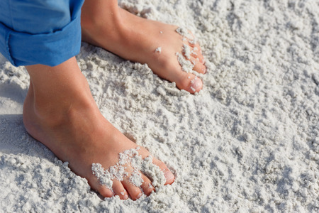 Close up of child feet on a tropical sandy beach, Florida, Siesta Key beachの写真素材
