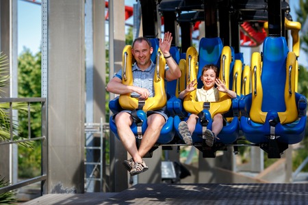 Father and his little son enjoy the ride at attraction parkの写真素材
