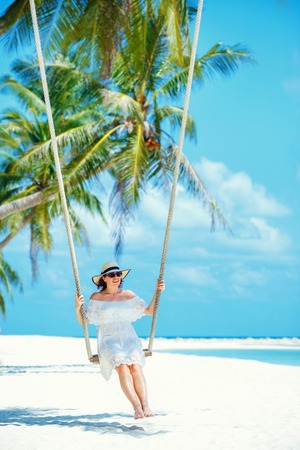 Beautiful woman swinging on a Tropical beach, Koh Phangan island. Thailandの写真素材
