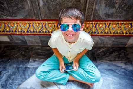 Cute little boy having rest in Grand Palace, Bangkokの写真素材