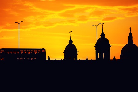 Sunset forming a silhouette of St. Paul, London Bridge and double deckersの写真素材
