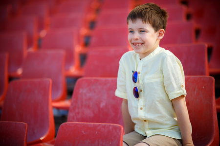 Cute little boy sits on a tribuneの写真素材
