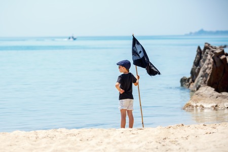 Cute boy dressed as pirate on tropical beachの写真素材