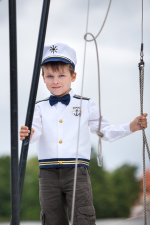 Cute toddler boy in captain costume enjoying boat rideの写真素材