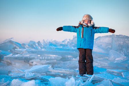 Cute little boy outdoors playing on winter beachの写真素材