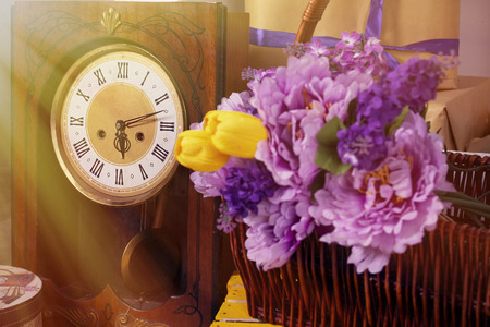 spring photo with retro clock flowers in a basket a box of gifts tulipsの写真素材