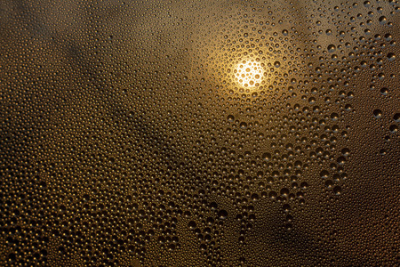 sunset through misted glass with drops and drips background rainの写真素材