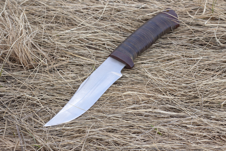 tourist knife on dry grass, hunting knife, killing, knife found, cold armsの写真素材