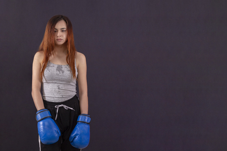 boxer girl boxing gloves standing tired and sweat on gray background copyspaceの写真素材