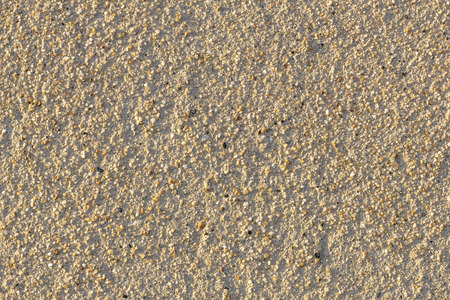 copyspace background texture beige wall of plaster with small colorful natural stonesの写真素材