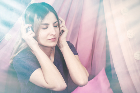 girl in headphones listening to music and enjoying smiling emotionsの写真素材