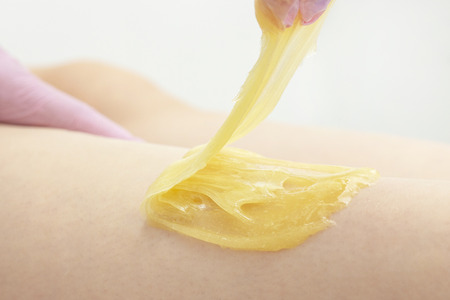 sugar depilation cosmetic procedure applying shugaring paste on skin for depilation in the beauty parlorの写真素材