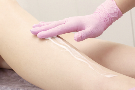 cosmetic procedure applying cream on the legs depilation epilation rubbing cream skin softeningの写真素材